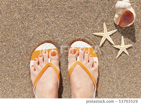 Female feet on sand 53703529
