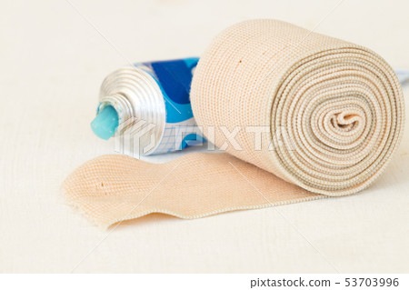 topical medication with roll bandage for first aid 53703996