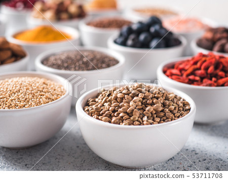 Hemp seeds in small white bowl and other superfood 53711708