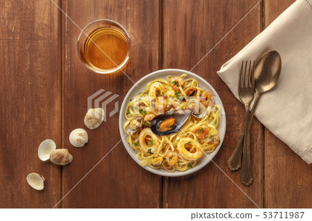 Seafood pasta. Tagliolini with mussels, shrimps, clams and squid rings, with a glass of wine, shells Seafood pasta. Tagliolini with mussels, shrimps, clams and squid rings, with a glass of wine, shells 53711987