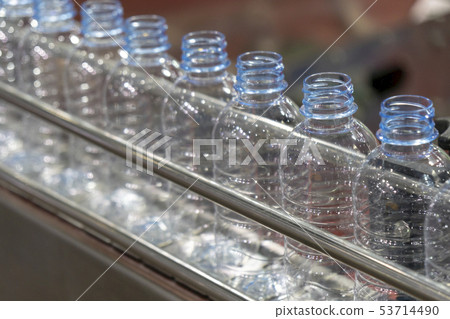 The plastic bottles in the conveyor belt. 53714490