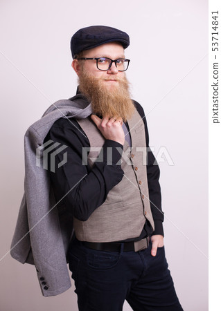 Handsome bearded man with jacket on his shoulder looking confident at the camera over white 53714841