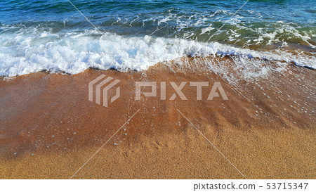 Sea wave with white foam on the coastal sand 53715347
