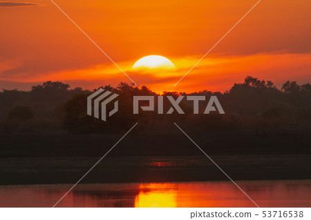 Sunset is behind clouds on the lake Sunset is behind clouds on the lake 53716538