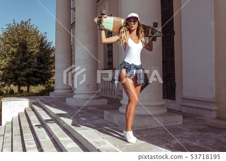 Girl summer in city, posing with a board, longboard skate, sunglasses baseball cap white bodysuit 53718195