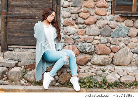 Young beautiful woman in stylish clothes sits 53718983