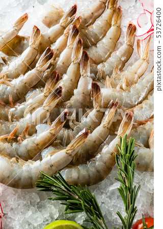 raw shrimps with lime and rosemary on the ice 53726400