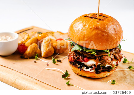 burger with sauce and vegetables 53726469