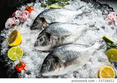 Fresh raw dorado fish and food ingredients on table 53726812