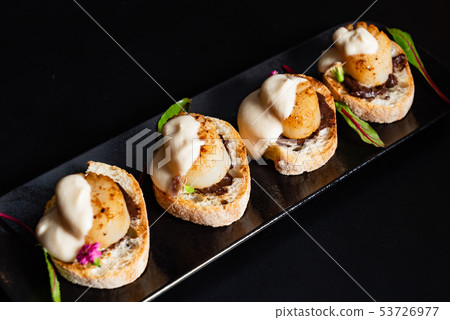 scallop appetizers with sauce on the black background scallop appetizers with sauce on the black background 53726977