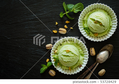 Pistachio ice cream in white bowl 53728429