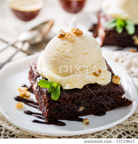 Chocolate brownie with vanilla ice cream, nuts and mint 53729621