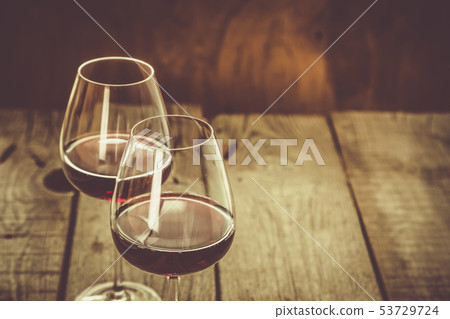 Glasses with red wine on rustic wood background Glasses with red wine on rustic wood background 53729724