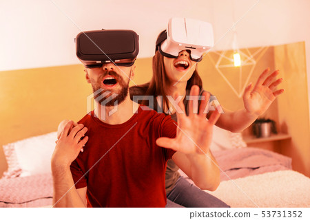Funny couple playing virtual games at home Funny couple playing virtual games at home 53731352