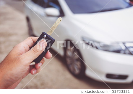 Man holding car keys with car on background 53733321