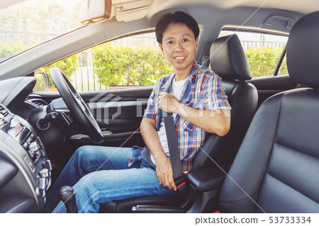 Asia man fastening seat belt in car Asia man fastening seat belt in car 53733334