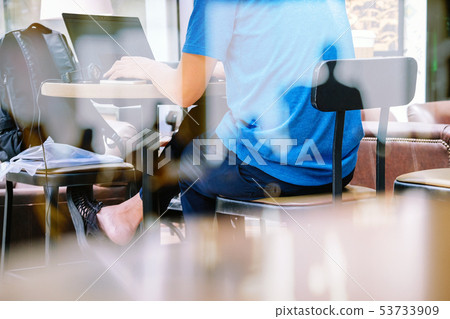 people Using his laptop in cafe 53733909