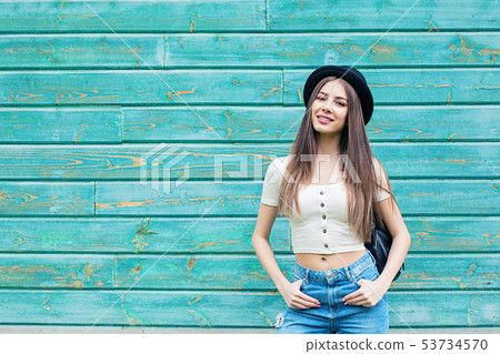 Smiling woman on blue wooden background outdoors Smiling woman on blue wooden background outdoors 53734570