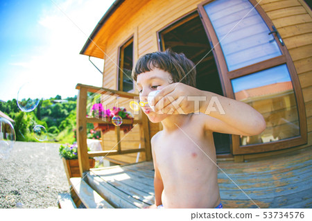 Boy kid blows bubbles. Boy kid blows bubbles. 53734576