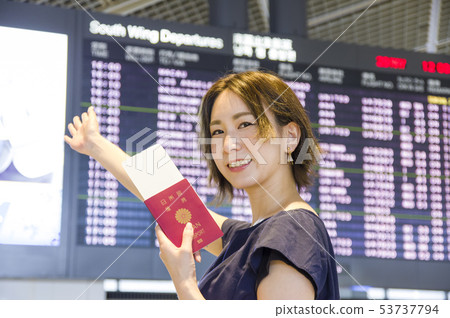 A woman looking at a departure board for international flights 53737794