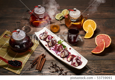 Delicious Asian dessert in white plate with steaming teapots, fruits, berries and spices. Asian menu Delicious Asian dessert in white plate with steaming teapots, fruits, berries and spices. Asian menu 53739091