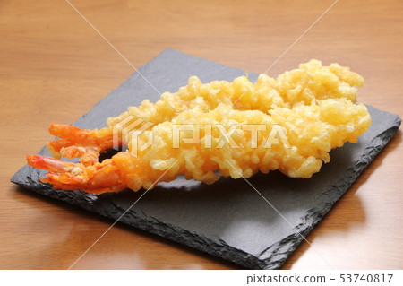 Two prawns tempura fried straight and placed on a slate plate. 53740817
