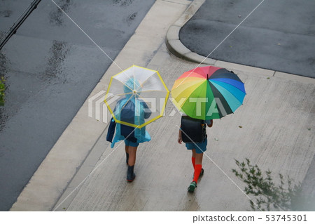 Children going to school on a rainy day. Children going to school on a rainy day. 53745301