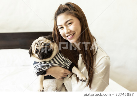 woman kissing her Cute dog pug 53745887