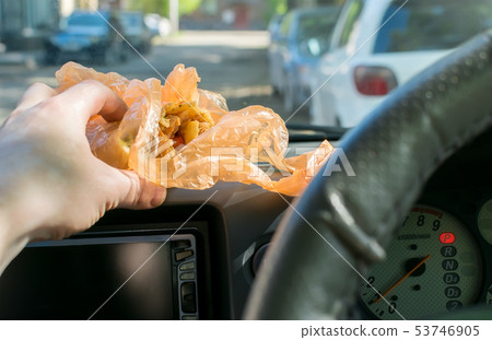 shawarma in the hand of the driver in the car 53746905