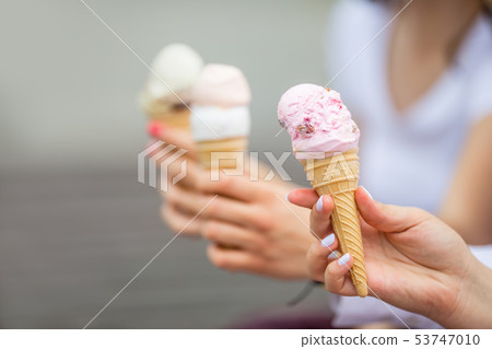 Delicious three ice cream in female hands - 53747010