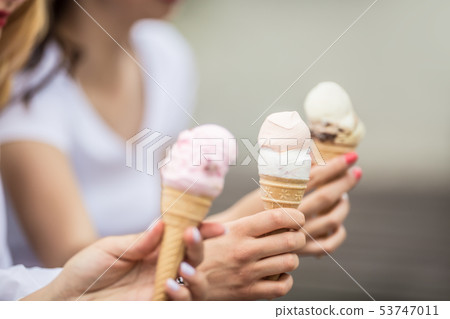 Delicious three ice cream in female hands - 53747011