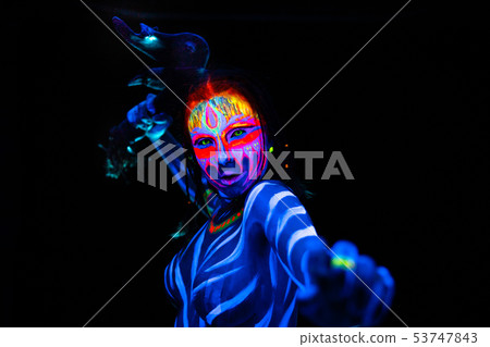Portrait of Young naked bodyarted woman in blue glowing ultraviolet paint with tomahawk ancient Portrait of Young naked bodyarted woman in blue glowing ultraviolet paint with tomahawk ancient 53747843