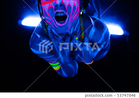 Close-up Portrait of Wild and frantic Young naked bodyarted woman in blue glowing ultraviolet paint Close-up Portrait of Wild and frantic Young naked bodyarted woman in blue glowing ultraviolet paint 53747846