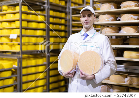 Portrait of inspector standing in production department of dairy factory and take view of redy Portrait of inspector standing in production department of dairy factory and take view of redy 53748307