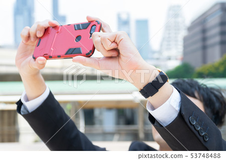 Business man taking a photo with mobile phone in 53748488