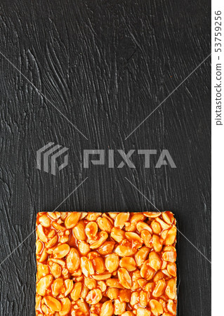 A large golden tile of peanuts, a bar in a sweet 53759256