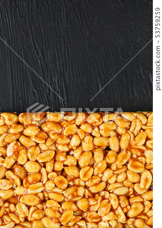 A large golden tile of peanuts, a bar in a sweet 53759259