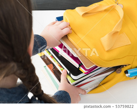 back to school girl packing books backpack 53759822