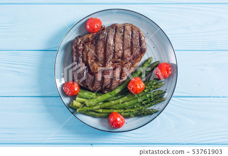 Grilled beef steak ribeye with cherry tomatoes and 53761903