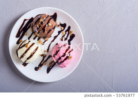 Ice cream with walnuts and chocolate topping 53761977