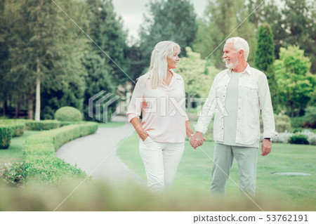 Delighted happy couple walking together in the park Delighted happy couple walking together in the park 53762191
