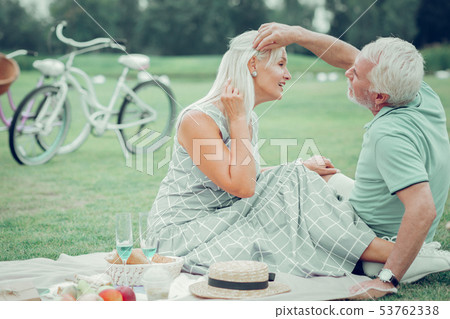 Delighted good looking woman showing her earrings 53762338