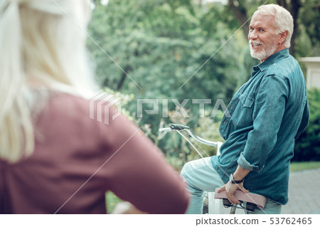 Delighted bearded man turning to his wife 53762465