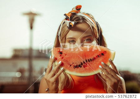 Face portrait of lady holding a watermelon piece near face Face portrait of lady holding a watermelon piece near face 53762872