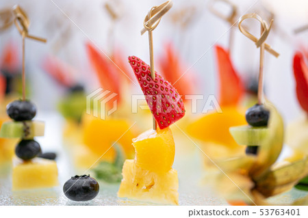 Buffet at the gala dinner. Canapes with cheese, pineapple and strawberries. Assortment of canapes Buffet at the gala dinner. Canapes with cheese, pineapple and strawberries. Assortment of canapes 53763401
