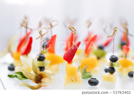 Buffet at the gala dinner. Canapes with cheese, pineapple and strawberries. Assortment of canapes Buffet at the gala dinner. Canapes with cheese, pineapple and strawberries. Assortment of canapes 53763402