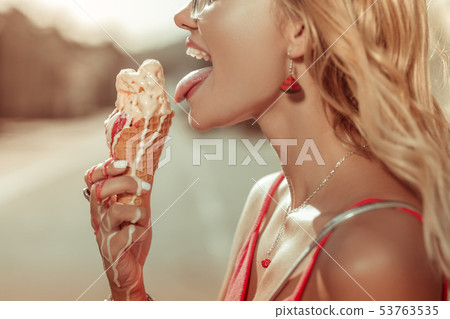 Close-up blonde bewitching young beauty going to leak an ice-cream Close-up blonde bewitching young beauty going to leak an ice-cream 53763535