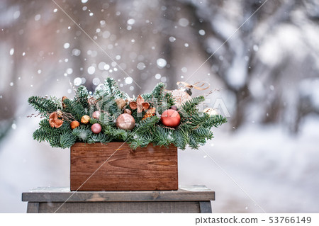 Beautiful festive arrangement of fresh spruce with ball toys in a rustic wooden box. Christmas mood Beautiful festive arrangement of fresh spruce with ball toys in a rustic wooden box. Christmas mood 53766149