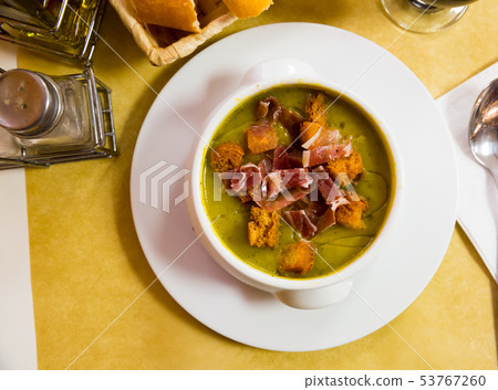 Top view of creamy zucchini soup with croutons and jamon 53767260