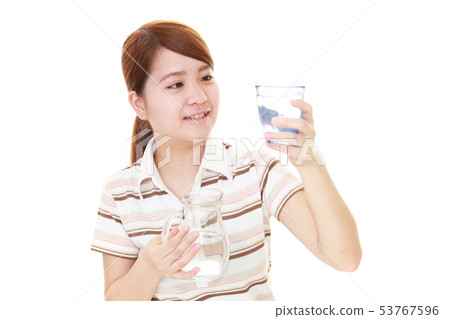 Smiling woman with glass of water Smiling woman with glass of water 53767596